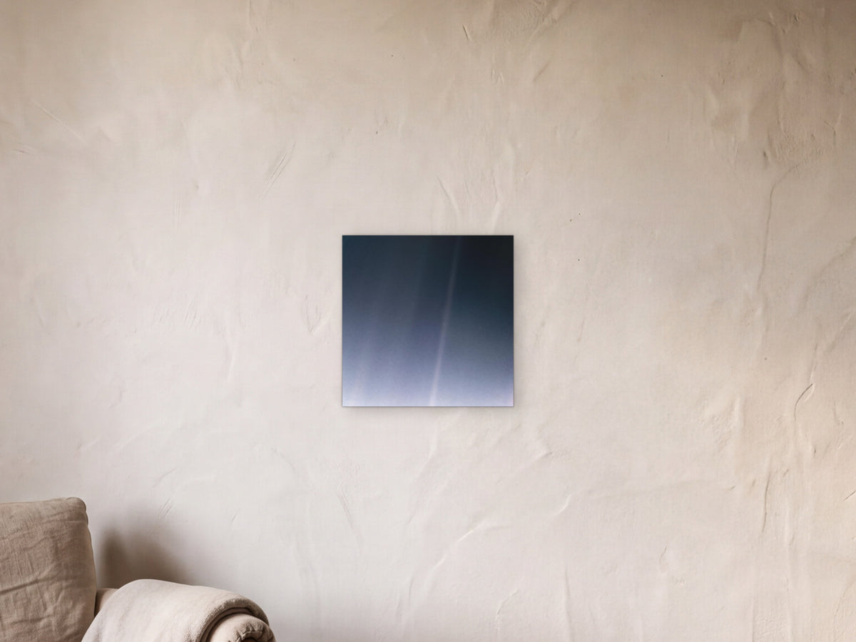 Pale Blue Dot Revisited (2020 remaster) shown in a limewash reading corner beside an armchair and a floor lamp - scale render at 40 × 40 cm